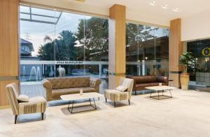 a lobby with couches and tables in a building at Sunday Platinum Suites in Bangkok