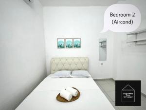 a bedroom with a bed with two towels on it at Homestay Meru Ipoh Mus Lim Only Tropical White House in Ipoh