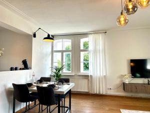 a dining room with a table and chairs and a window at Boutique Apartment im historischen Bahnhof - Potsdam & Berlin in Potsdam