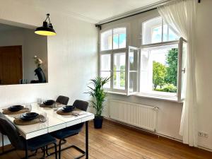 a dining room with a table and chairs and a window at Boutique Apartment im historischen Bahnhof - Potsdam & Berlin in Potsdam