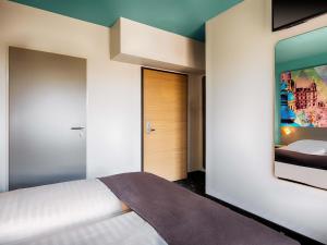 a bedroom with a bed and a painting on the wall at B&B Hotel Graz-Hbf in Graz