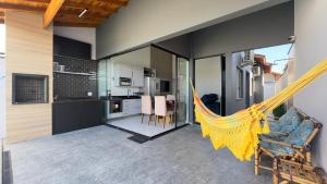 a living room with a hammock in a house at Casa Moderna para Familias com Piscina Churrasqueira Wi-Fi e Ar Condicionado in Peruíbe