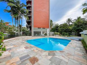 a swimming pool in front of a building at Cobertura Pé na Areia - Enxoval Completo Riviera in Riviera de São Lourenço