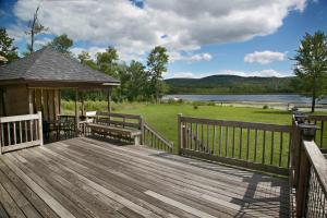 una terraza de madera con cenador y lago en The Quiet Cove on Wood Road, en Bradford