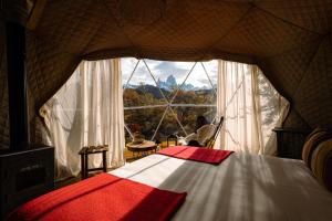 a bedroom with a bed and a large window at Chalten Camp - Glamping with a view in El Chalten