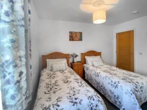 a bedroom with two beds and a window at No 8 Cottage in Aviemore