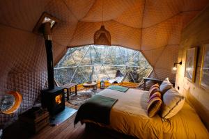 a bedroom with a large window in a tree house at Chalten Camp - Glamping with a view in El Chalten