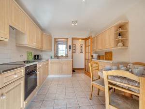 a kitchen with wooden cabinets and a table at Eryb Cottage - Uk46883 in Kilmory