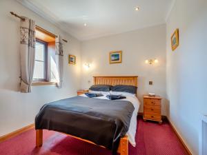 a bedroom with a large bed and a red carpet at Eryb Cottage - Uk46883 in Kilmory