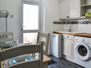 a kitchen with a washer and dryer and a table at The Apartment in Filey