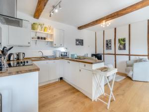 a kitchen with white cabinets and a table at Rambler's Hideaway - Uk45414 in Eaton Bishop