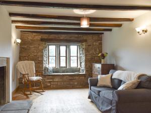 a living room with a couch and a window at Kirkstall Wood Farm in Ingrow