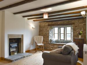 a living room with a couch and a fireplace at Kirkstall Wood Farm in Ingrow