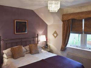 a bedroom with a bed and a window at 9 Howrah's Court in Keswick
