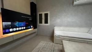 Habitación con TV de pantalla plana y cama. en شقة الزهور, en Al Nairyah