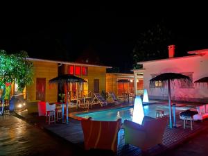 a swimming pool at night with chairs and tables at Toti guest house 3 in São Tomé