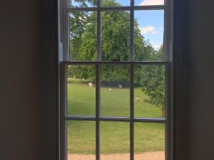 an open window looking out at a field of grass at The Stable in Womenswold +6 photos