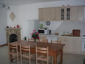 a kitchen with a wooden table with chairs and a fireplace at Gite Périgourdin - 3 Chambres in Labrousse