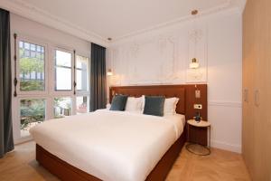 a bedroom with a large bed with white sheets at Mode Paris Aparthotel in Paris