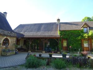 a house with a tile roof and a patio at Gite Périgourdin - 2 Chambres in Labrousse +4 photos