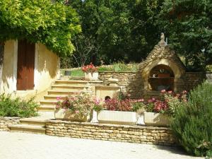 a stone wall with some flowers in a garden at Gite Périgourdin - 2 Chambres in Labrousse