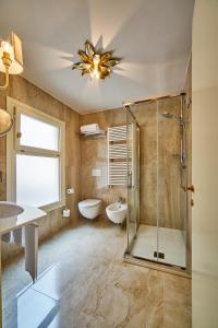 a bathroom with a shower and a tub and a sink at Hotel Gardena in Venice