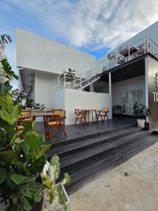 an outdoor deck with wooden tables and chairs at Treat Boutique HuaHin 94 in Hua Hin