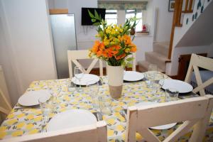 un tavolo da pranzo con un vaso di fiori sopra di Pine Cottage Little Haven a Little Haven
