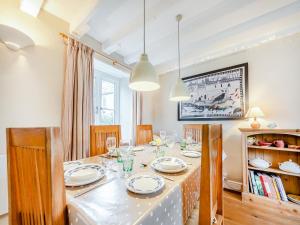 ein Esszimmer mit einem Tisch mit Tellern und Gläsern in der Unterkunft Trewellwell Cottage in Middle Mill