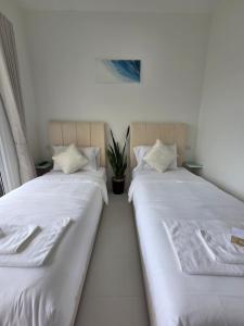 two beds sitting next to each other in a room at Treat Boutique HuaHin 94 in Hua Hin