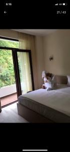 a small child sitting on a bed next to a window at Seastar in Kvariati