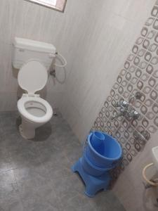 a bathroom with a toilet and a blue bucket at Naksh Villa in Mahabaleshwar +17 photos