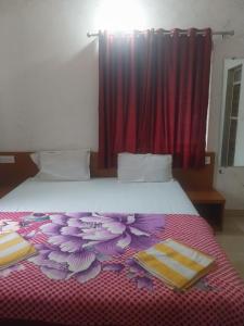 a bedroom with a large bed with a red curtain at Naksh Villa in Mahabaleshwar