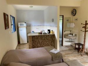 a bedroom with a bed and a kitchen with a sink at Fazenda Camping Cabral in São Lourenço