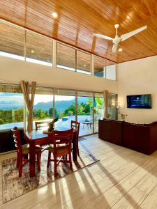 a dining room with a table and chairs and a ceiling fan at Casa de Teak in Savegre