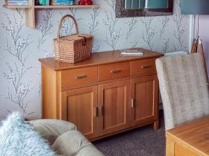 un armadio in legno con un cesto in cima di Tyglyn Cottage a Lampeter