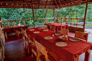 a dining room with a red table and chairs at Samora River Lodge in Arusha