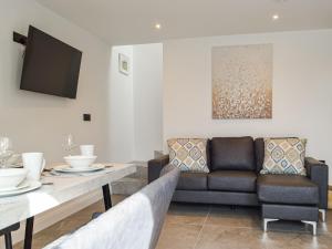 ein Wohnzimmer mit Sofa und Tisch in der Unterkunft Hafan Gwyn - Cottage in Verwick