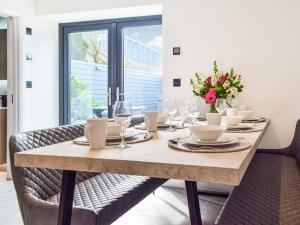 ein Esstisch mit Gläsern und Blumen darauf in der Unterkunft Hafan Gwyn - Cottage in Verwick