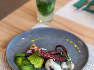 a plate of food with a octopus and vegetables on a table at ibis Concepcion in Concepción