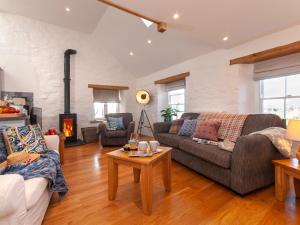un soggiorno con divano e camino di The Loft - Cottage a Letterston