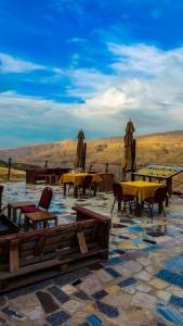 a group of tables and chairs and umbrellas on a patio at Mumia heritage restaurant & house in Kerak