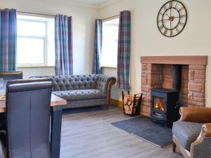 a living room with a couch and a fireplace at West Lanegate Farmhouse in Amisfield Town