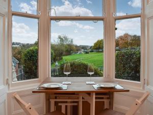 a table with two wine glasses in front of a window at Whitby Bliss in Whitby