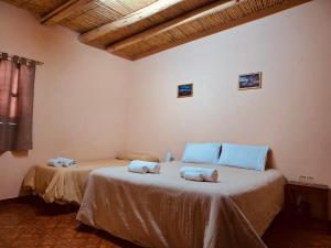 a bedroom with two beds with towels on them at EL AMANECER hospedaje y excursiones in El Peñón