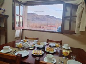 a table with plates of food and a window at EL AMANECER hospedaje y excursiones in El Peñón