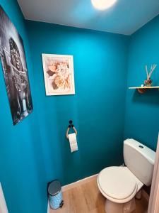 a bathroom with blue walls and a white toilet at Gite de Clairette et Nono in Lantignié-en-Beaujolais