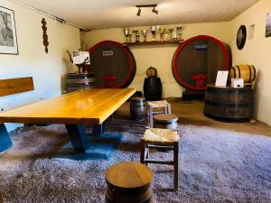 a room with two wine barrels and a wooden table at Gite de Clairette et Nono in Lantignié-en-Beaujolais +2 photos