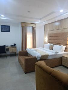 a bedroom with a large bed and a couch at Immaculate Excellence Luxury Hotels Ltd in Owerri +18 photos