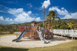 een speeltuin met een glijbaan in het zand bij Au beau village studio vue nature in Sainte-Luce